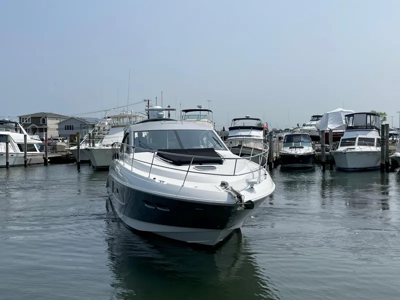 Slide: The Image of A 2018 Sea Ray Sundancer 510 docked in a marina, surrounded by other boats. - 18