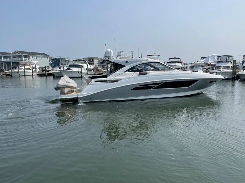 Slide: The Image of A 2018 Sea Ray Sundancer 510 is in the water, surrounded by other boats in the marina. - 9