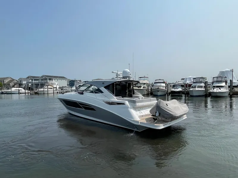 Slide: The Image of A 2018 Sea Ray Sundancer 510 is in the water, surrounded by other boats in the marina. - 31