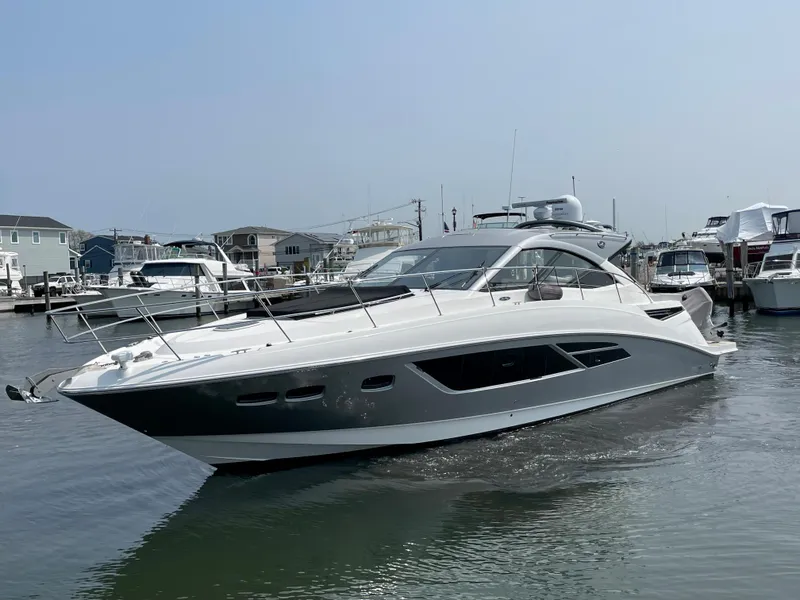 Slide: The Image of The 2018 Sea Ray Sundancer 510 is docked in a marina. It features a sleek, modern design. - 22
