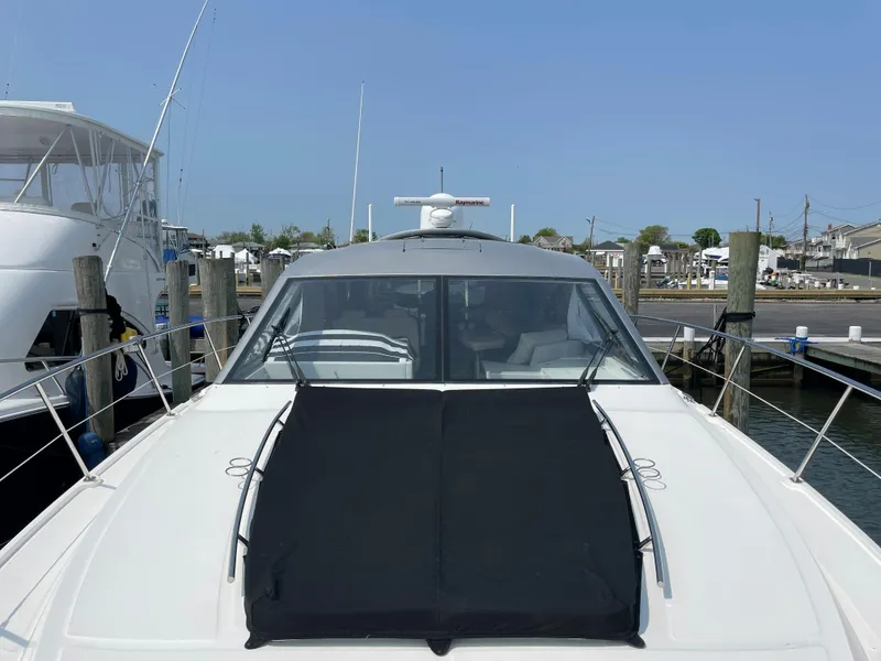 Slide: The Image of 2018 Sea Ray Sundancer 510 docked at a marina, featuring a black cover on the foredeck. - 39