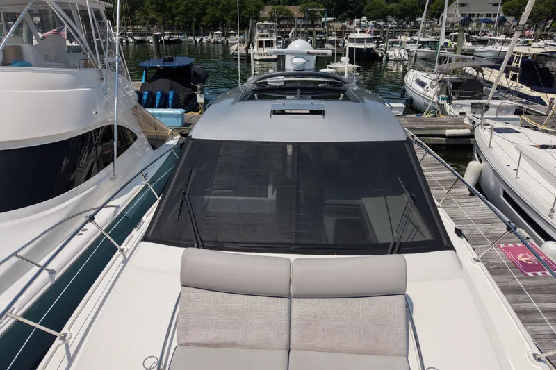 Slide: The Image of 2018 Sea Ray Sundancer 510 yacht docked at a marina, surrounded by other boats. - 83