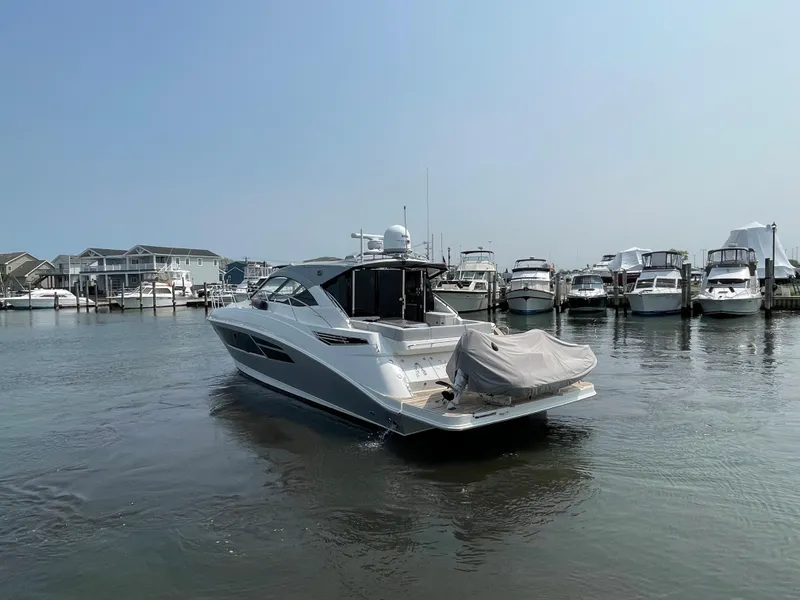 Slide: The Image of A 2018 Sea Ray Sundancer 510 is in the water, surrounded by other boats in the marina. - 32
