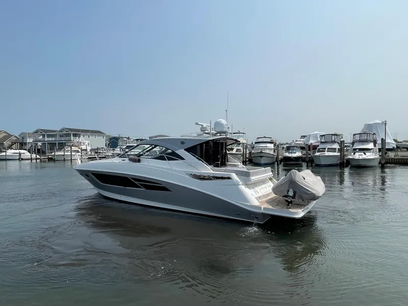 Slide: The Image of A 2018 Sea Ray Sundancer 510 is in the water, surrounded by other boats in the marina. - 30