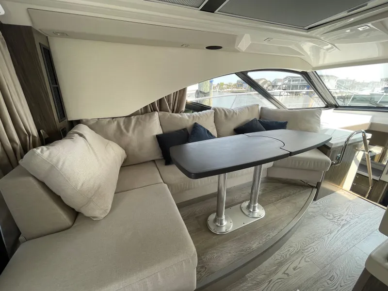 Slide: The Image of Interior of a 2018 Sea Ray Sundancer 510 with beige sofa and table. - 48