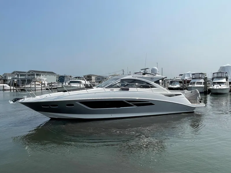 Slide: The Image of A 2018 Sea Ray Sundancer 510 is in the water, surrounded by other boats in the marina. - 25