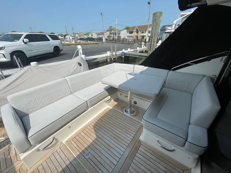 Slide: The Image of The image shows the cockpit of a 2018 Sea Ray Sundancer 510 with gray upholstered seating and a table. - 43
