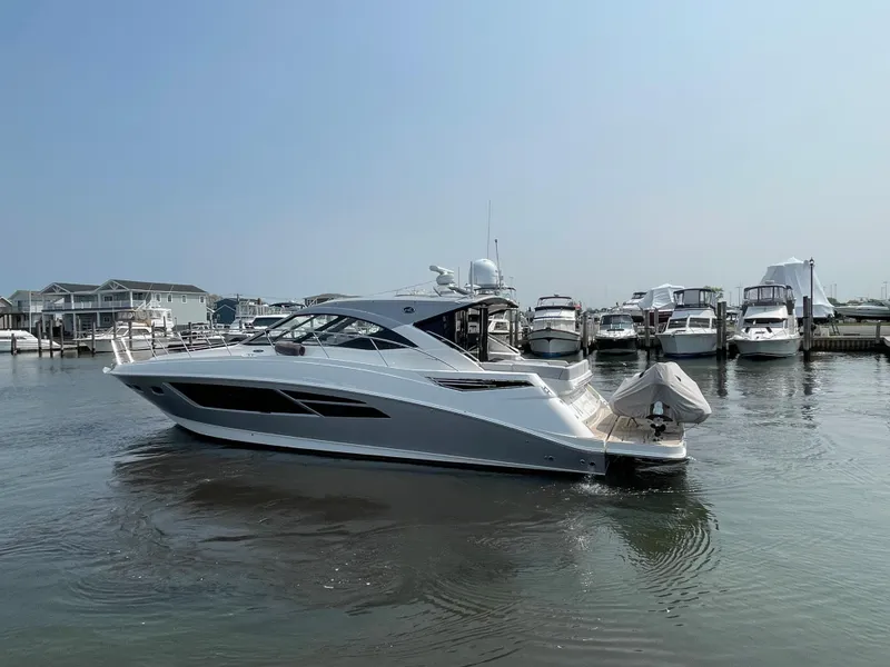 Slide: The Image of A 2018 Sea Ray Sundancer 510 is in the water at a marina, surrounded by other boats. - 29