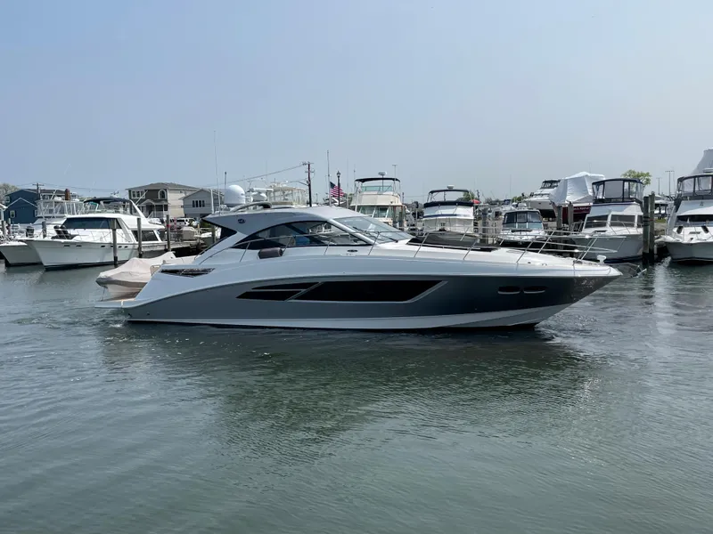 Slide: The Image of A 2018 Sea Ray Sundancer 510 is in the water, surrounded by other boats in the marina. - 12