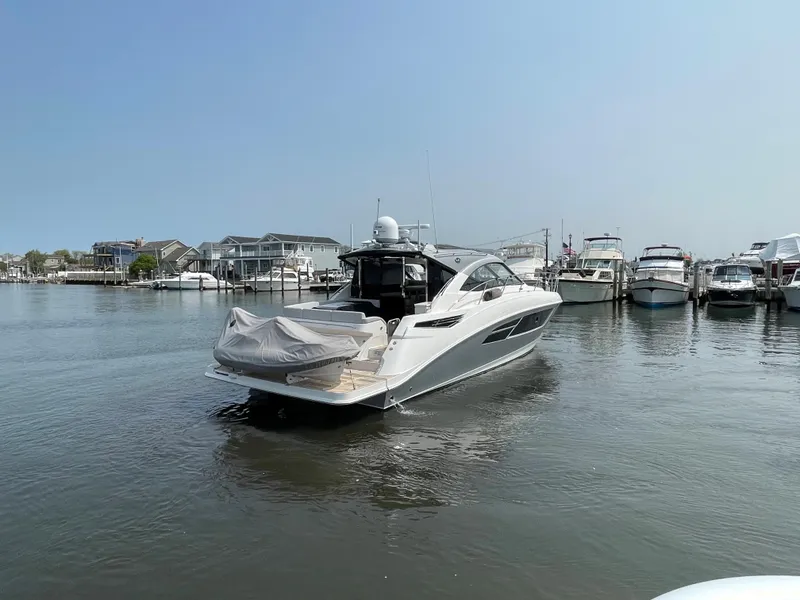 Slide: The Image of A 2018 Sea Ray Sundancer 510 is in the water, surrounded by other boats in the marina. - 37