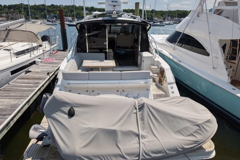 Slide: The Image of 2018 Sea Ray Sundancer 510 yacht docked at marina, covered jet ski on deck. - 85