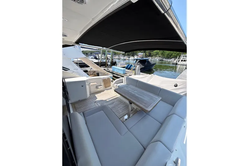 Slide: The Image of 2018 Sea Ray Sundancer 510 yacht with outdoor seating at a marina. - 90