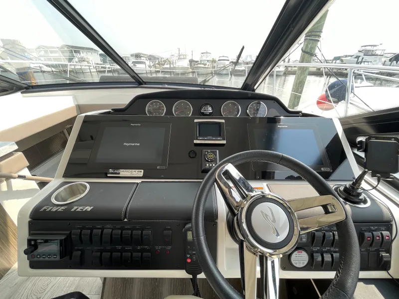 Slide: The Image of The image shows the helm of a 2018 Sea Ray Sundancer 510 with modern instruments. - 54
