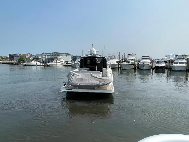 Slide: The Image of A 2018 Sea Ray Sundancer 510 is in the water, surrounded by other boats in the marina. - 35