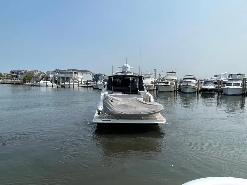 Slide: The Image of A 2018 Sea Ray Sundancer 510 is in the water, surrounded by other boats in the harbor. - 34