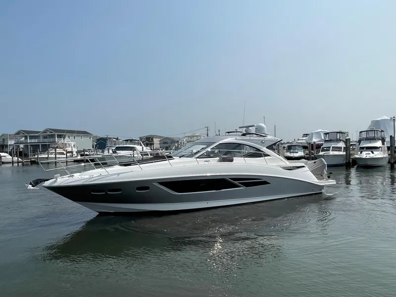 Slide: The Image of A 2018 Sea Ray Sundancer 510 is in the water, surrounded by other boats in the marina. - 24