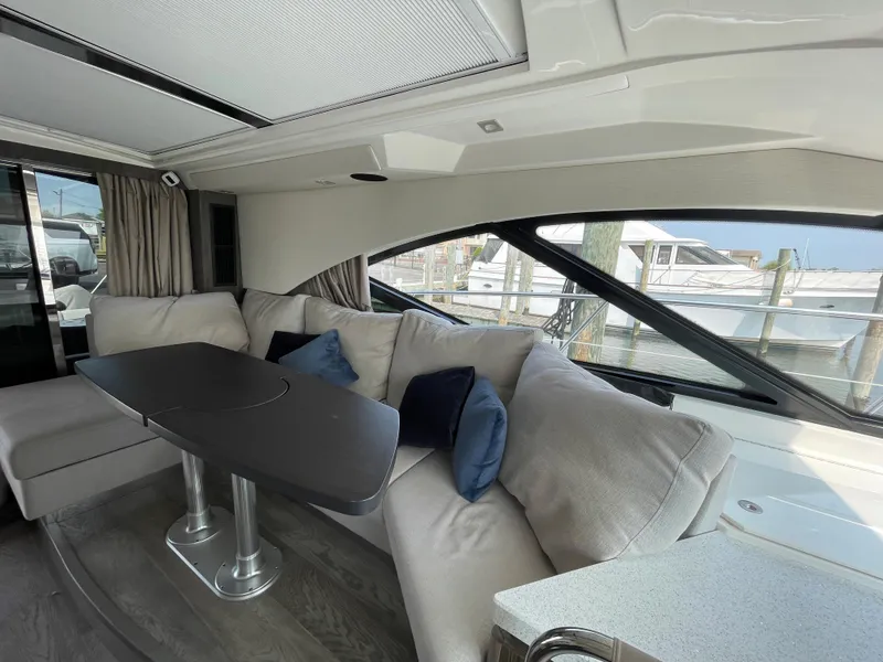 Slide: The Image of Interior of the 2018 Sea Ray Sundancer 510 with elegant seating area and table. - 50