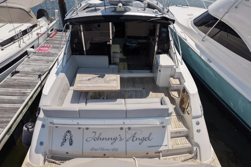 Slide: The Image of 2018 Sea Ray Sundancer 510 yacht docked, featuring spacious seating and elegant design. - 84