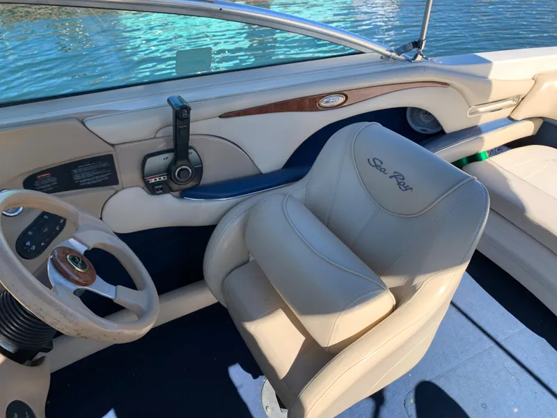 Slide: The Image of Interior of a 2000 Sea Ray 210 Bow Rider boat with steering wheel and captain's chair. - 13