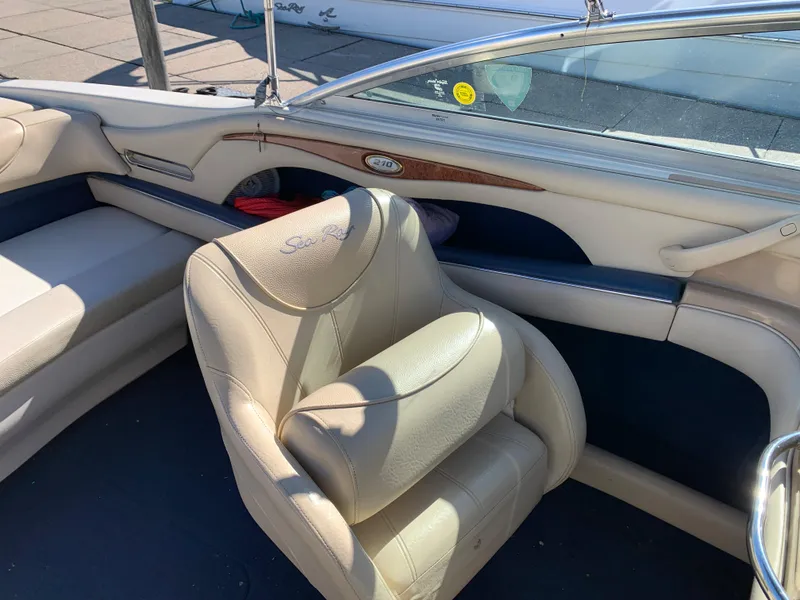 Slide: The Image of Interior of a 2000 Sea Ray 210 Bow Rider boat with beige leather seats. - 14