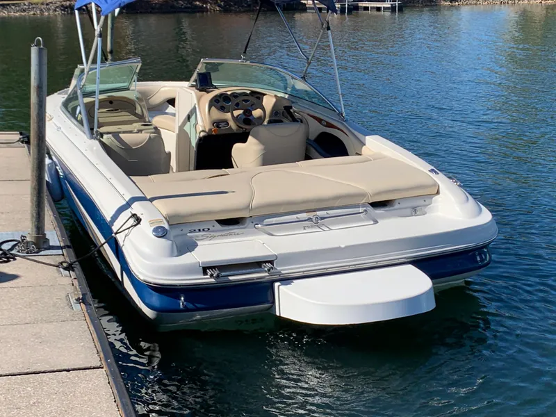 Slide: The Image of 2000 Sea Ray 210 Bow Rider docked on calm water. - 5