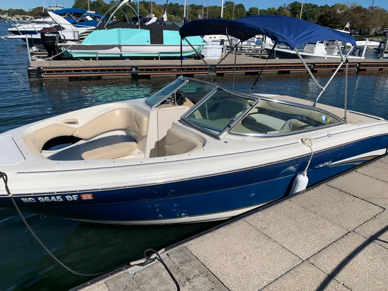 Slide: The Image of 2000 Sea Ray 210 Bow Rider boat docked at a marina. - 9