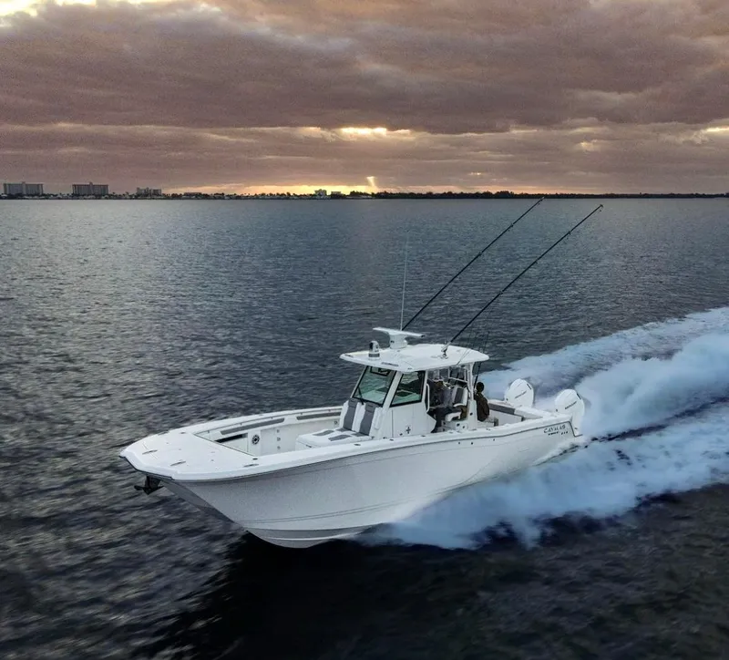 Slide: The Image of 2024 Caymas 34 CT boat cruising on open water at sunset. - 0