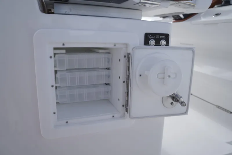 Slide: The Image of Storage compartment on 2024 Caymas 34 CT boat with tackle boxes and control panel. - 11