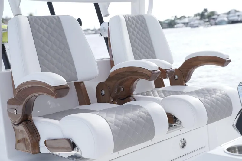 Slide: The Image of Luxury seating on 2024 Caymas 34 CT boat with quilted upholstery and wooden armrests. - 4