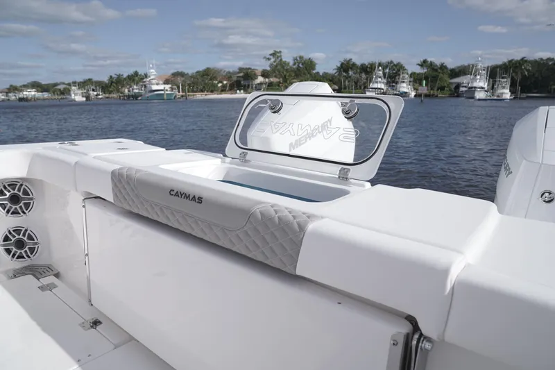 Slide: The Image of 2024 Caymas 34 CT boat interior with open storage compartment by the water. - 5