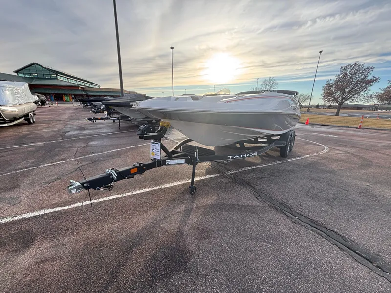 Slide: The Image of 2023 Tahoe 2150 boat on trailer in parking lot at sunrise. - 1