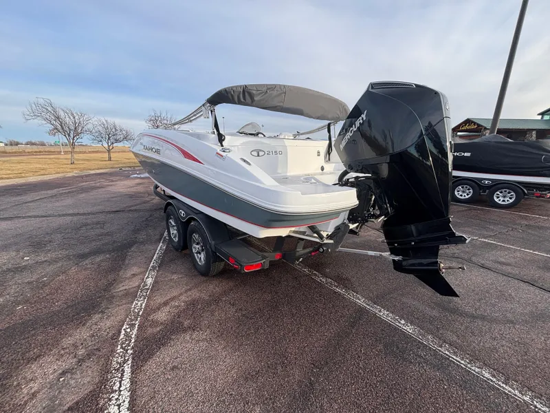 Slide: The Image of 2023 Tahoe 2150 boat on trailer, parked outdoors, showcasing sleek design and powerful engine. - 4