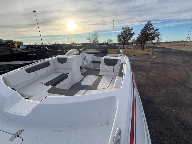Slide: The Image of 2023 Tahoe 2150 boat with spacious seating, parked outdoors under a cloudy sky. - 8