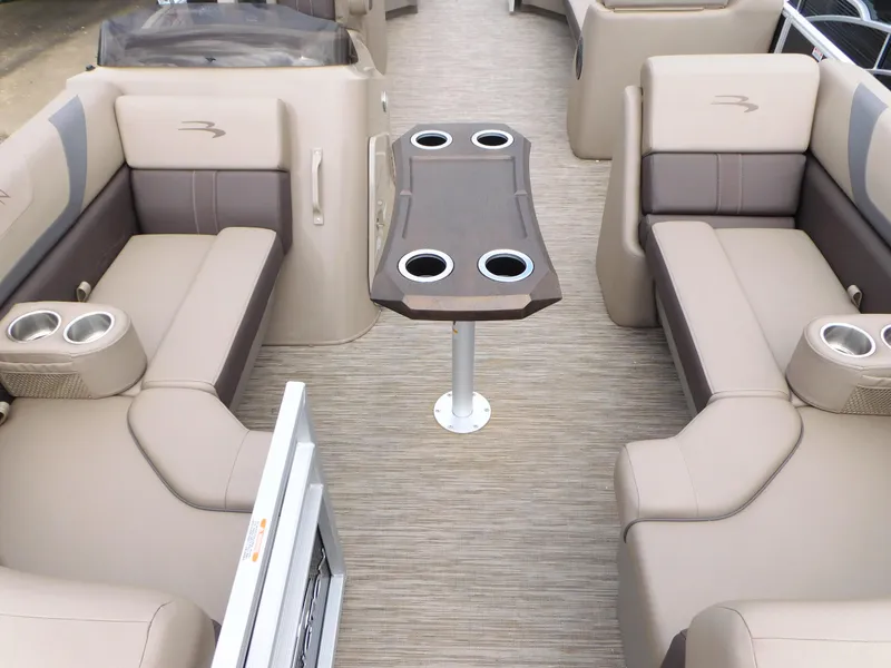 Slide: The Image of 2023 Bennington 22 SXSRC boat interior with beige seating and central table. - 3