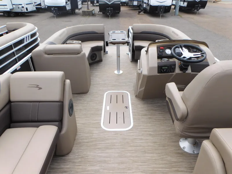 Slide: The Image of 2023 Bennington 22 SXSRC pontoon boat interior with beige seating and steering console. - 6