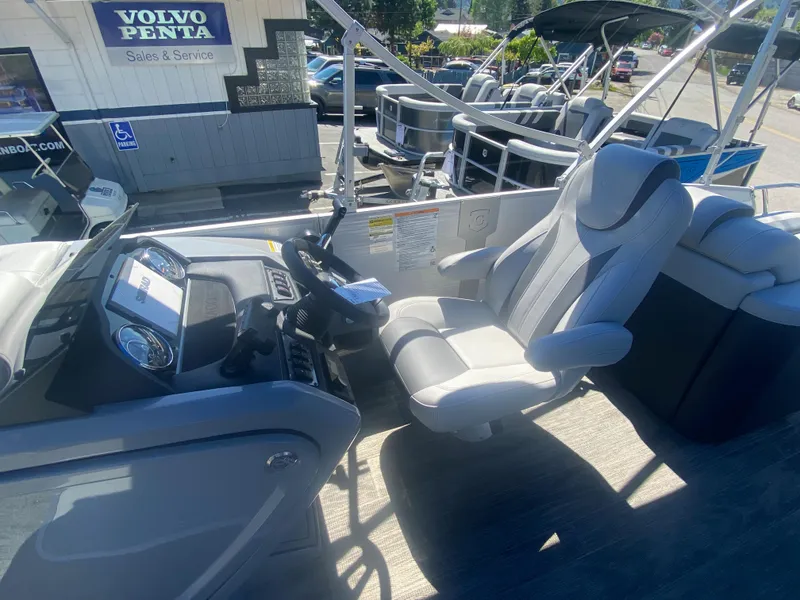 Slide: The Image of 2023 Godfrey Monaco 235 Rear Lounge boat interior with captain's chair and control panel. - 5