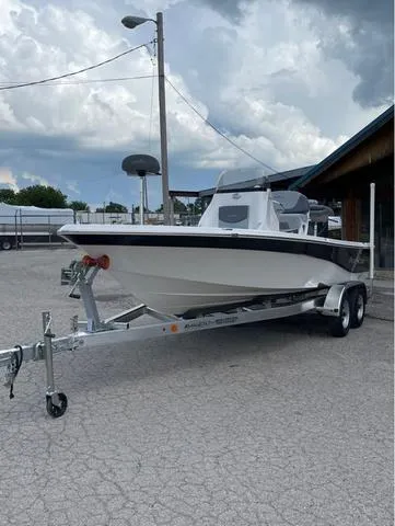 Slide: The Image of 2023 NauticStar 215 Bay boat on a trailer in a parking lot. - 2