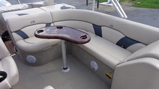 Slide: The Image of 2014 Avalon Wind Jammer boat interior with beige seating and a wooden table. - 10