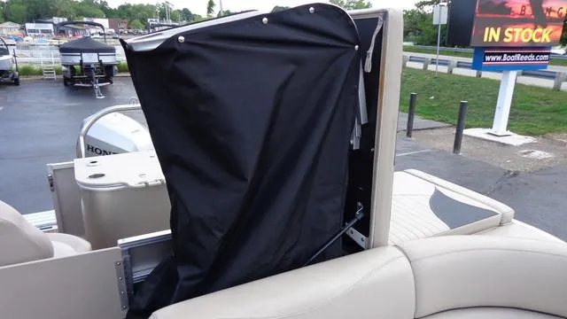 Slide: The Image of 2014 Avalon Wind Jammer boat with black cover and Honda outboard motor. - 5