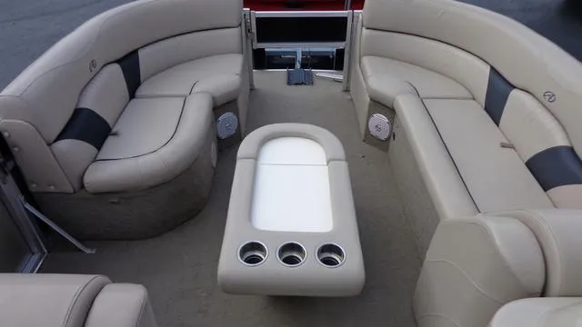 Slide: The Image of 2014 Avalon Wind Jammer boat interior with beige seating and cup holders. - 8