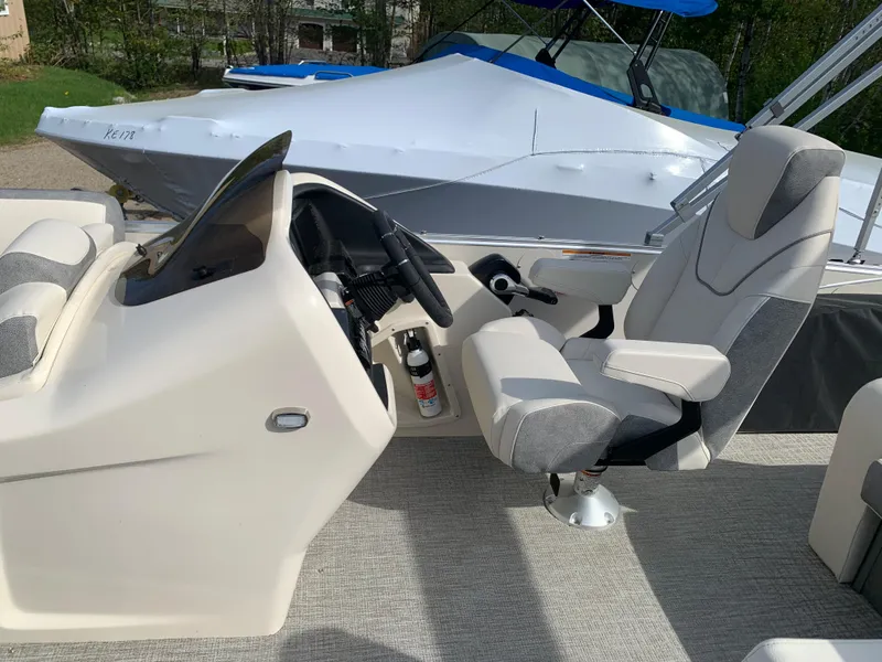 Slide: The Image of 2023 Avalon Catalina VRL 25' Tri-Toon boat interior with captain's chair and steering console. - 31