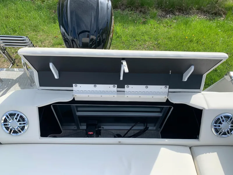 Slide: The Image of 2023 Avalon Catalina VRL 25' Tri-Toon storage compartment with open lid and speakers. - 47