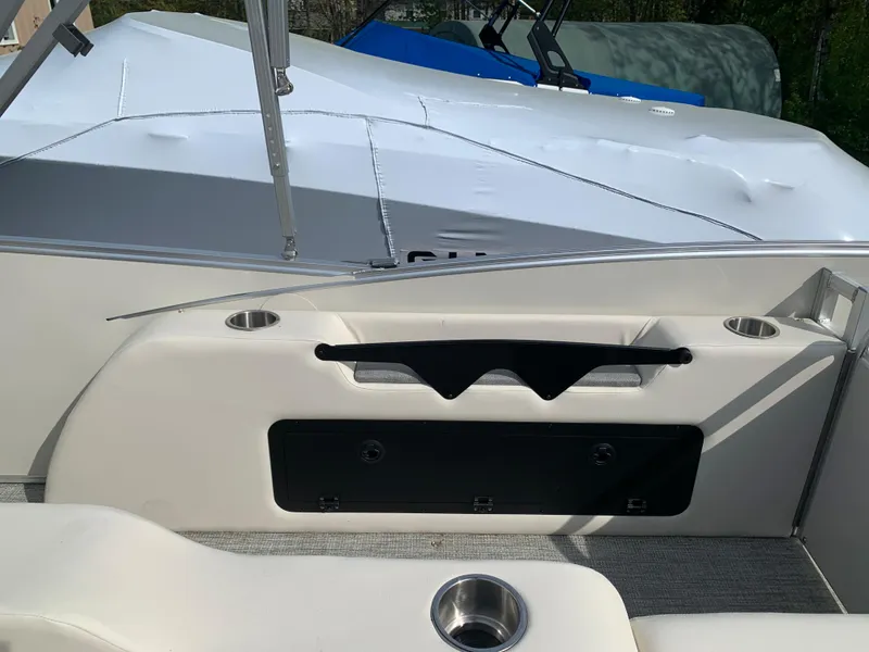 Slide: The Image of 2023 Avalon Catalina VRL 25' Tri-Toon boat interior with cup holders and storage compartment. - 49