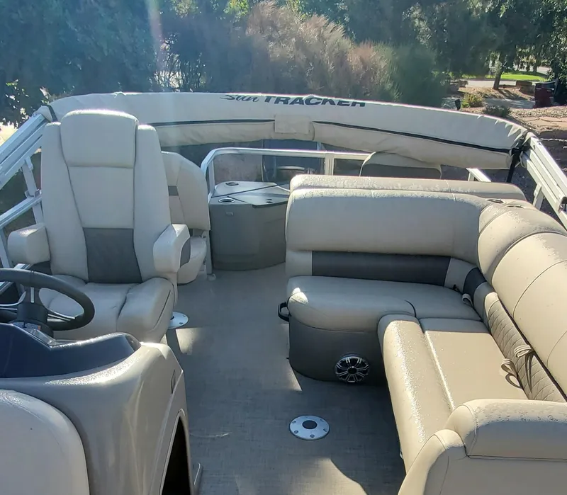 Slide: The Image of 2023 Sun Tracker Party Barge 22 XP3 interior with beige seating and steering console. - 4