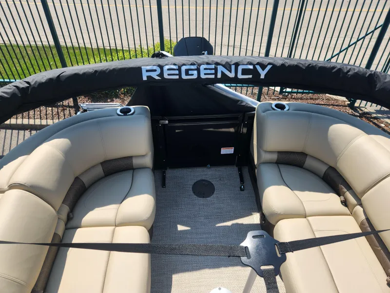 Slide: The Image of 2023 Regency 230 LE3 boat interior with beige seating and black canopy. - 11