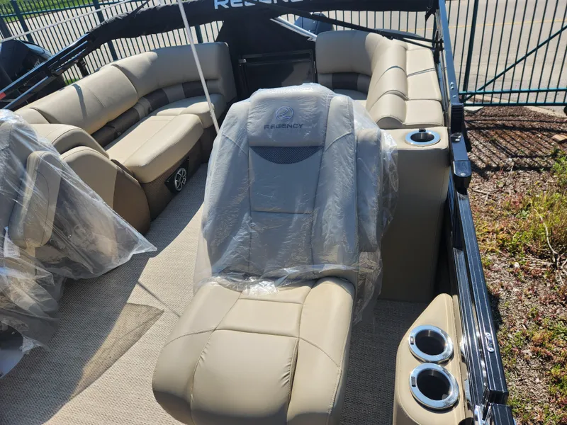 Slide: The Image of 2023 Regency 230 LE3 boat interior with beige seating and cup holders. - 12