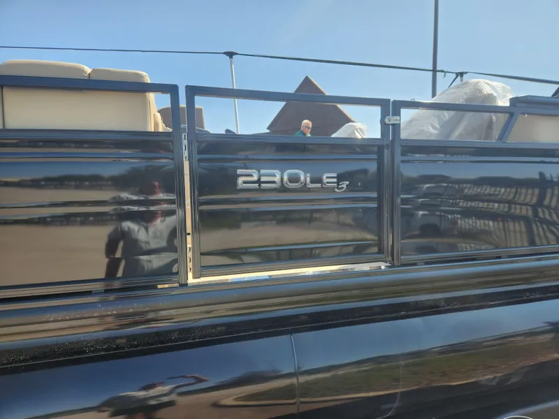 Slide: The Image of 2023 Regency 230 LE3 pontoon boat side view with model name. - 15
