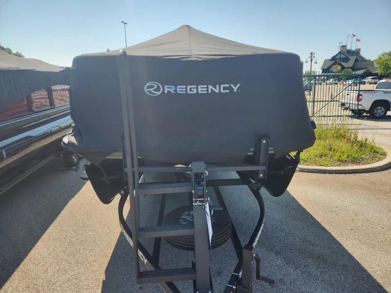 Slide: The Image of 2023 Regency 230 LE3 boat covered and parked on a trailer. - 4