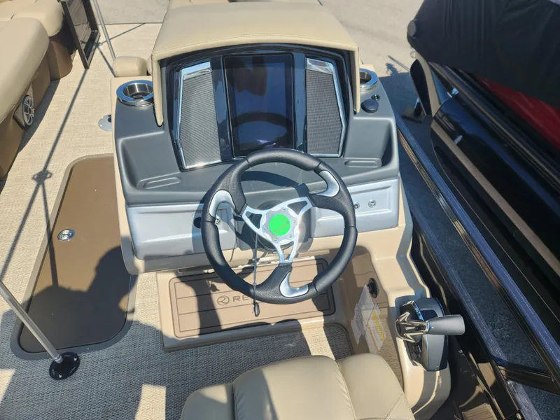 Slide: The Image of 2023 Regency 230 LE3 boat helm with steering wheel and control panel. - 5