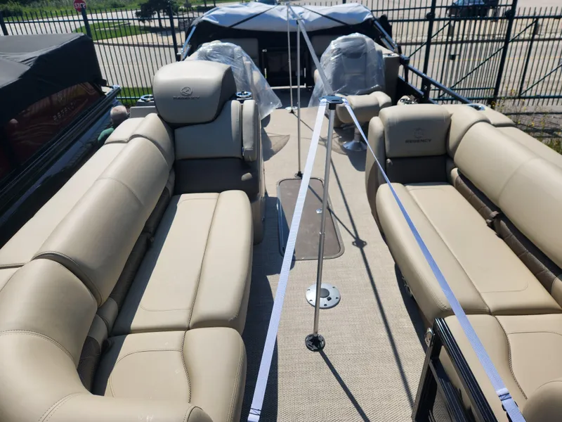 Slide: The Image of 2023 Regency 230 LE3 pontoon boat with beige seating and spacious deck. - 7
